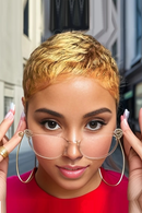 Woman with short blonde hair wearing gold hoop earrings and a red top, Obroi