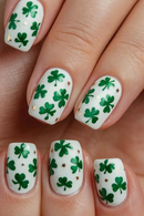 Nails with green shamrock designs on a white background, Obroi
