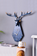Decorative wall clock shaped like a deer head on a gray wall, Obroi