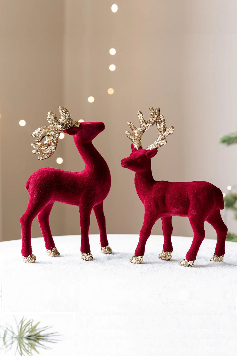 Two red deer figurines with gold antlers on a white surface, Obroi