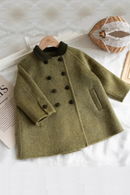 Green coat with black buttons on a white surface, Obroi