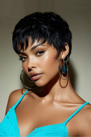 Woman with short black hair wearing large hoop earrings and a blue top against a neutral background, Obroi
