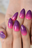 Purple and pink gradient nail design on a hand, Obroi