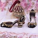 Obroi Decorative black high-heeled shoes with gold embellishments on a floral background