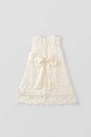 An off-white sleeveless lace dress for toddlers, featuring a large satin bow at the center front, delicate floral embroidery, and a scalloped lace hem, shown against a solid light gray background, Obroi
