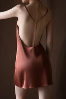 Person wearing a sheer top and pink slip dress against a dark background, Obroi