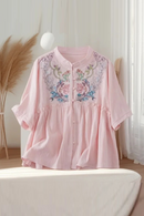 Pink blouse with floral embroidery on a white surface, Obroi