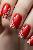 Close-up of red nails with floral designs on a blurred background, Obroi
