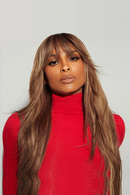 Woman with long brown hair wearing a red turtleneck against a light gray background, Obroi