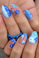Nails with blue and white floral design on a hand, Obroi