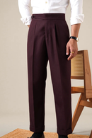 Person wearing maroon pleated pants and a white shirt, standing against a neutral background, Obroi