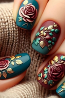 Nails with floral design in teal, purple, and gold on a textured surface, Obroi