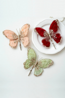 Butterfly-shaped decorative item with glittery details on a white background, Obroi