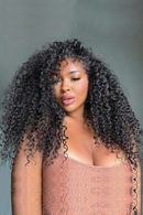 Woman with voluminous curly hair against a gray background, Obroi