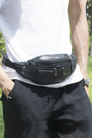 Person wearing a black leather waist bag outdoors, Obroi