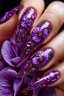 Nails with purple floral design and glitter against a purple flower background, Obroi