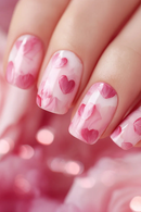 Nails with pink heart design on a blurred pink background, Obroi