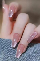 Close-up of a hand with pink glittery nail polish on a blurred background, Obroi