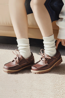 Brown shoes with white socks on a carpeted floor, Obroi