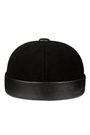 A black structured cap with a suede-like crown and a smooth leather-look brim, shown from the front on a plain white background, Obroi