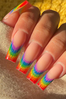A close-up of a hand with long square nails painted in a rainbow gradient that fades from bright neon colors at the tips to a sheer nude base, Obroi