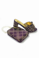 A pair of purple glittery mule heels with a gold plaid pattern, featuring a gold insole and a white faux-pearl chain strap, shown on a white background, Obroi