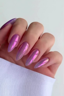 Hand with pink and purple metallic nail design on a white background, Obroi