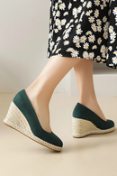 Green wedge sandals with textured sole worn with a floral dress on a neutral background, Obroi