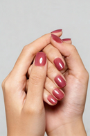 Close-up of hands with pink nail polish on a plain background, Obroi